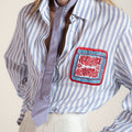 Women's blue and white striped cotton shirt with intricate Miao embroidery, contemporary design inspired by traditional craftsmanship.