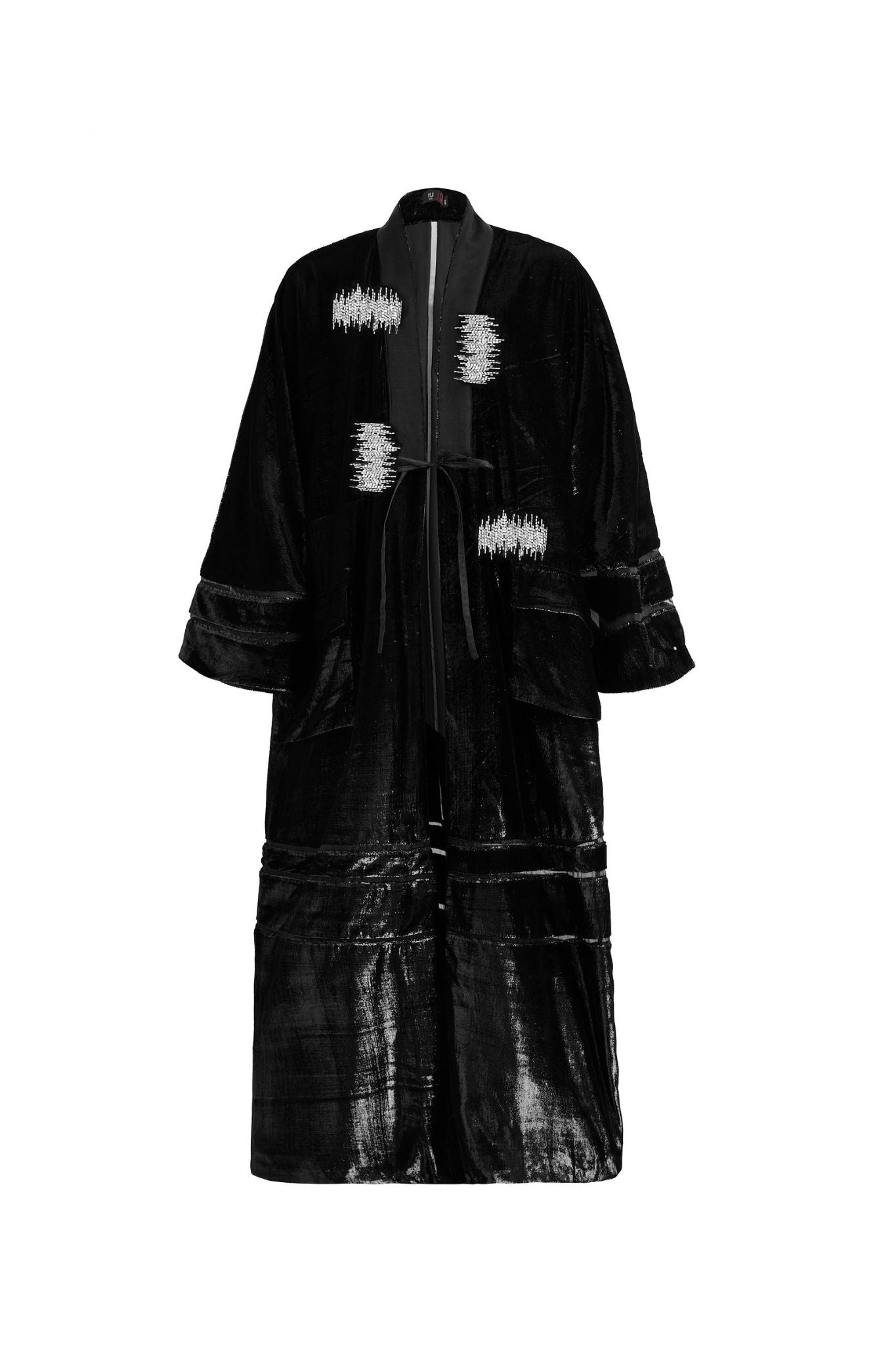 Hui Milano long black velvet Chinese-style coat with collar and sequin-detailed edges, adjustable waist belt, wide hem, and embroidered tube bead accents, elegant flowing silhouette blending tradition and modern sophistication, front view on white background.