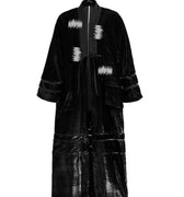 Hui Milano long black velvet Chinese-style coat with collar and sequin-detailed edges, adjustable waist belt, wide hem, and embroidered tube bead accents, elegant flowing silhouette blending tradition and modern sophistication, front view on white background.