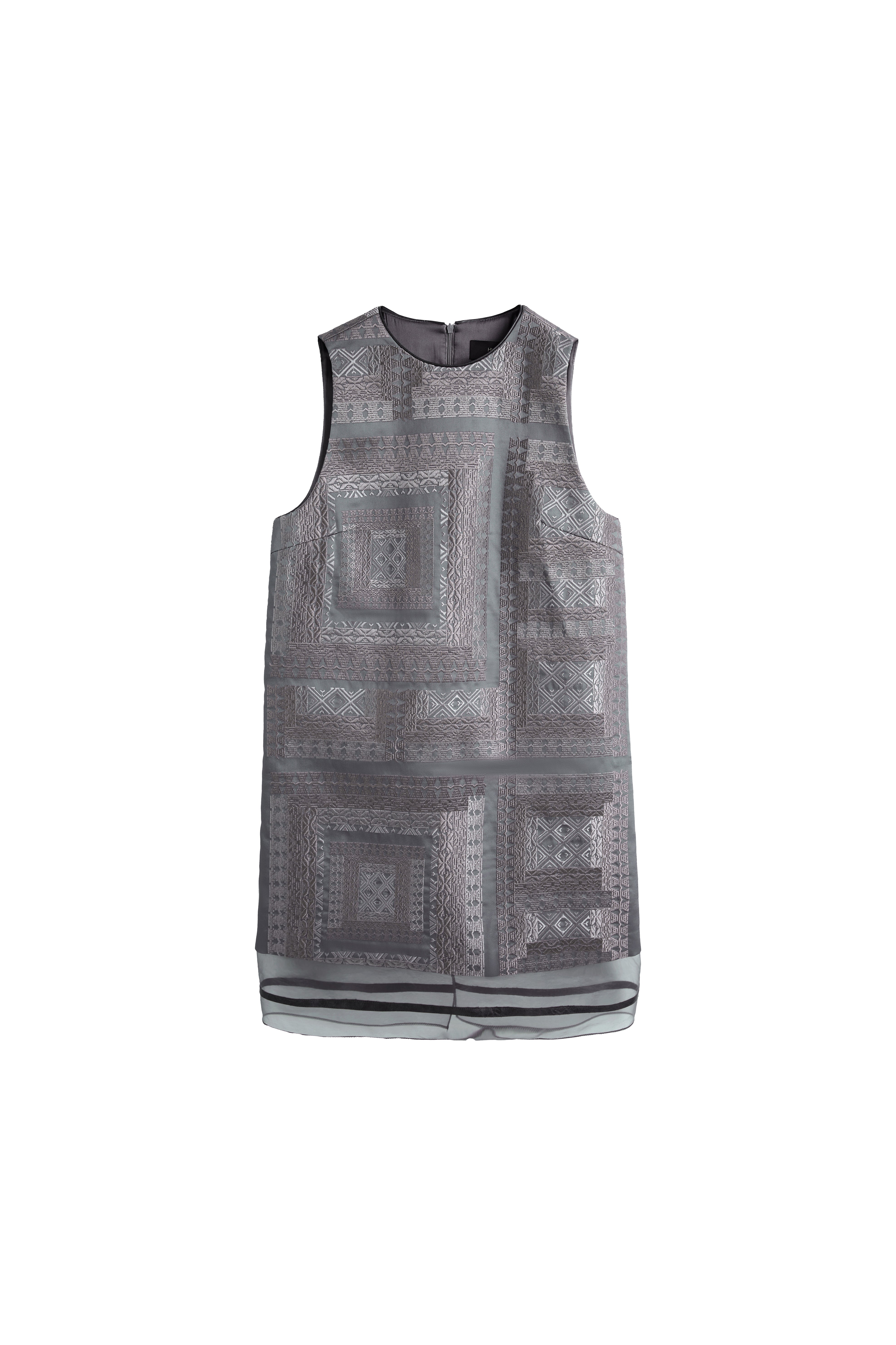 Hui Milano sleeveless grey A-line dress fully adorned with traditional Miao embroidery, intricate patterns with sheer hem inserts, blending cultural craftsmanship with contemporary fashion, front view on white background.
