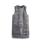 Hui Milano sleeveless grey A-line dress fully adorned with traditional Miao embroidery, intricate patterns with sheer hem inserts, blending cultural craftsmanship with contemporary fashion, front view on white background.