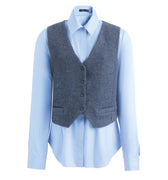 Hui Milano two-in-one outfit featuring grey wool V-neck waistcoat with single buttons and pockets, paired with blue silk shirt with collar and long sleeves, versatile and sophisticated layered look, front view on white background.