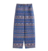 Hui Milano wide-leg blue pants with intricate jacquard Miao ethnic motifs, buttoned waistband, relaxed fit for comfort, elegant and culturally inspired design, front view on white background.
