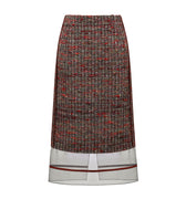Hui Milano classic wool skirt with delicate organza inserts and subtle red stripe accents, elegant hemline design combining wool and transparent organza for modern and sophisticated style, front view on white background.
