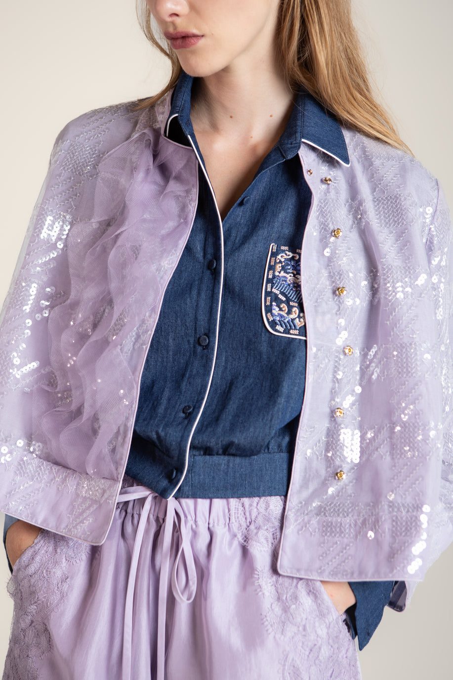 Purple sequin coat with wave-inspired ruffle details and traditional Chinese stand collar, elegant outerwear blending cultural heritage with modern sophistication.