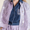 Purple sequin coat with wave-inspired ruffle details and traditional Chinese stand collar, elegant outerwear blending cultural heritage with modern sophistication.